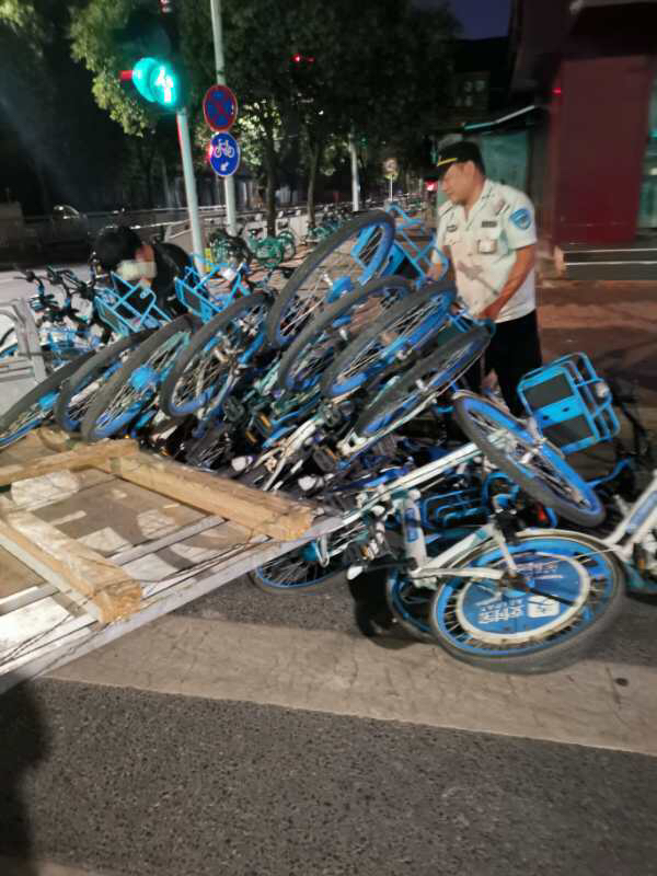 单车|好险！小伙骑着平板加长三轮运送共享单车，拐弯太急翻车被“埋”