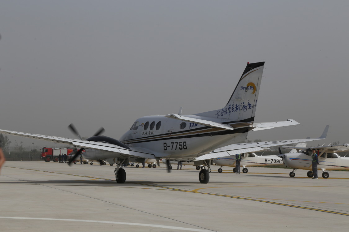 随着马达轰鸣,气流成风,两架银白色的飞机划过碧绿的麦田,翱翔在周口