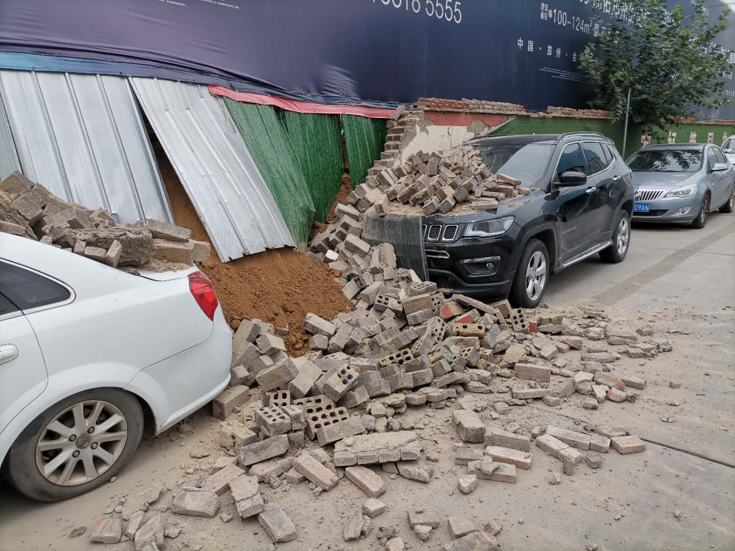 郑州一处建筑工地围墙倒塌，两车险遭“活埋” 