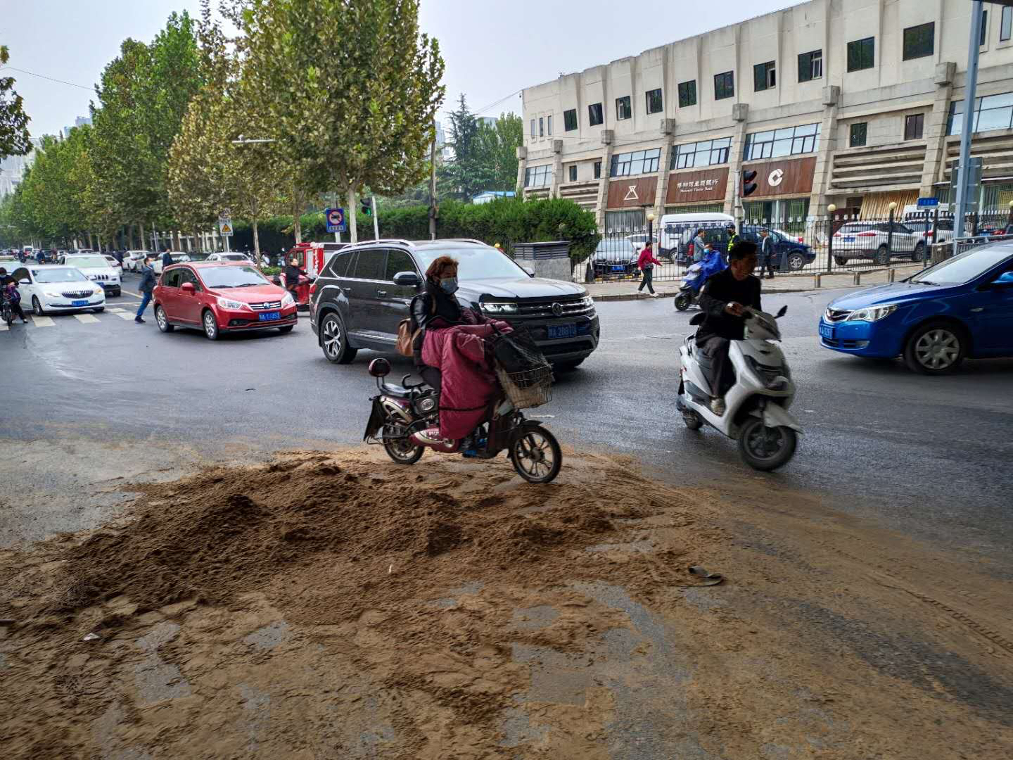 |大货车超高拉沙从高架桥下经过时被“削平”，落下一地沙子扬长而去……