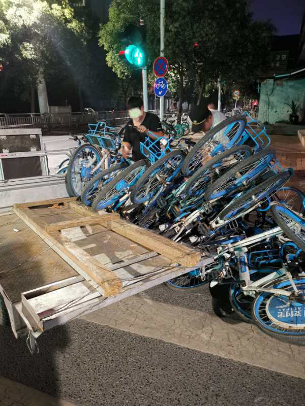 单车|好险！小伙骑着平板加长三轮运送共享单车，拐弯太急翻车被“埋”