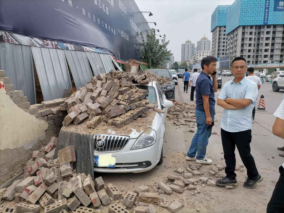 郑州一处建筑工地围墙倒塌，两车险遭“活埋” 