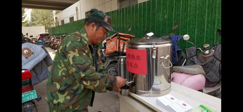 公交站牌下成劳务市场有人提供免费热水喝