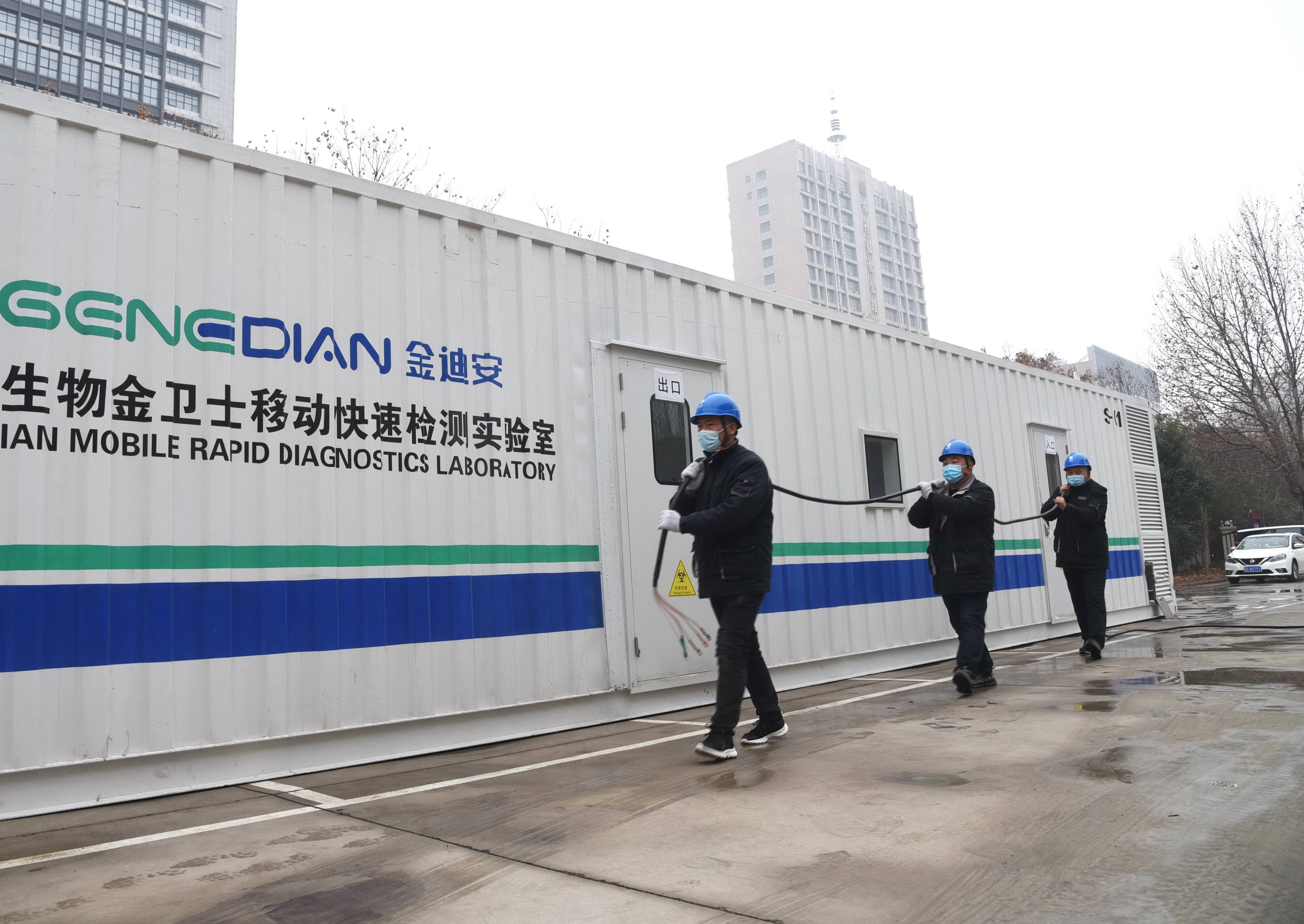 1月6日,国网许昌供电员工紧急行动，火速为位于许昌新区实验学校内的新建方舱核酸快检实验室进行临时接电。(焦永生摄)
