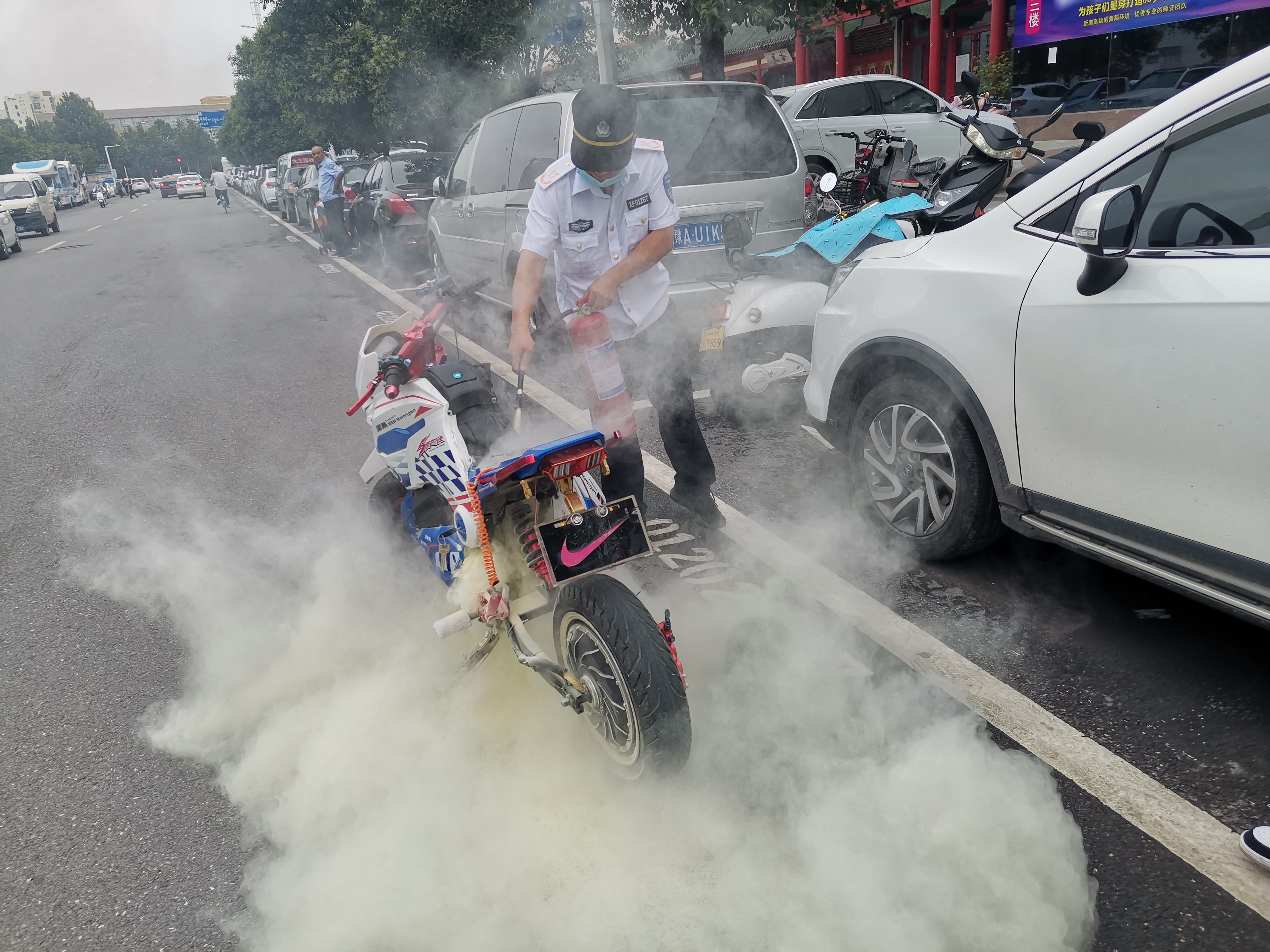 电动汽车|男孩骑电动车在街头行驶，电动车突然冒烟起火