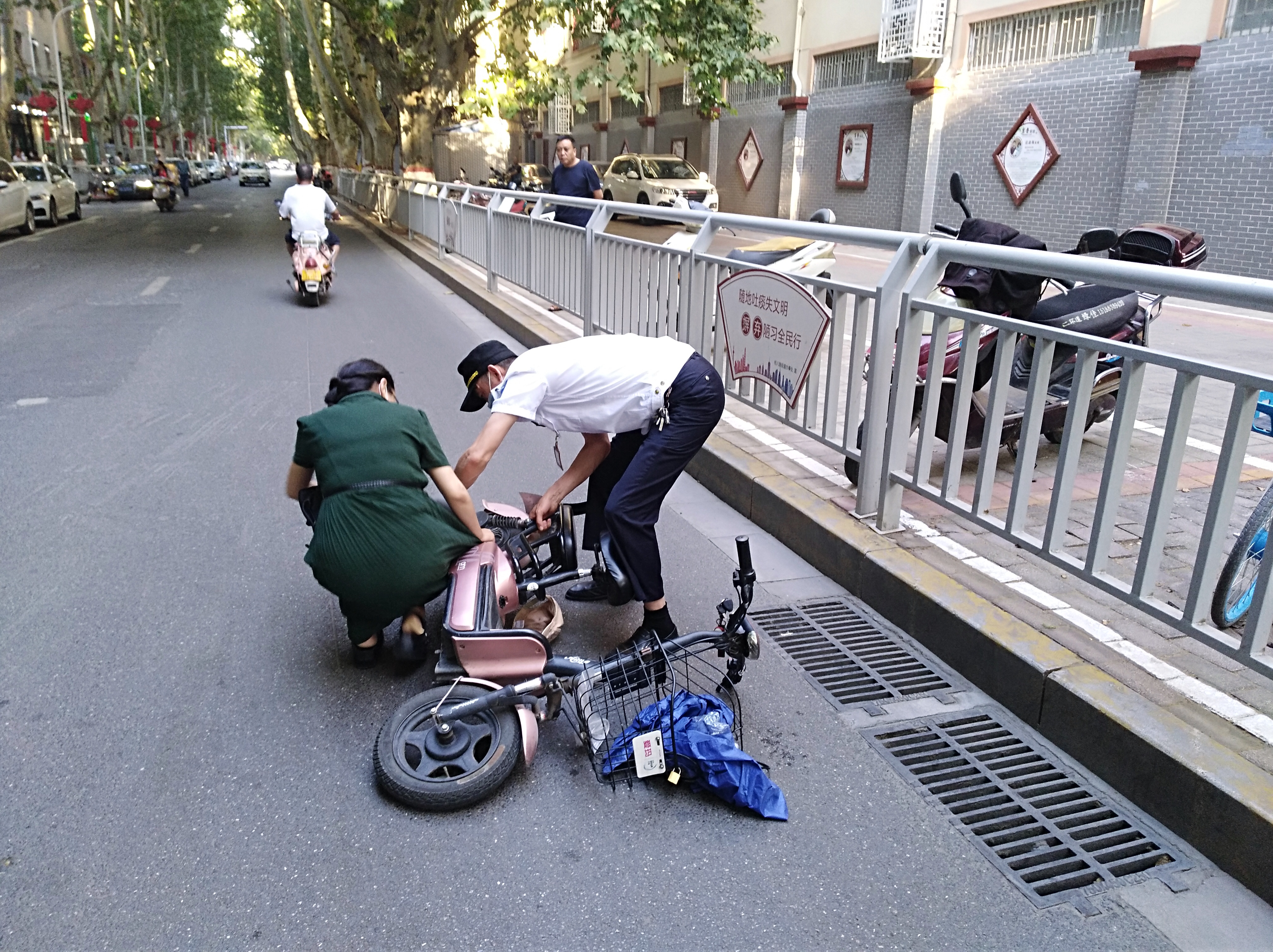 电动汽车|尴尬！女子骑电动车裙角卷入车轮，连人带车摔倒在地