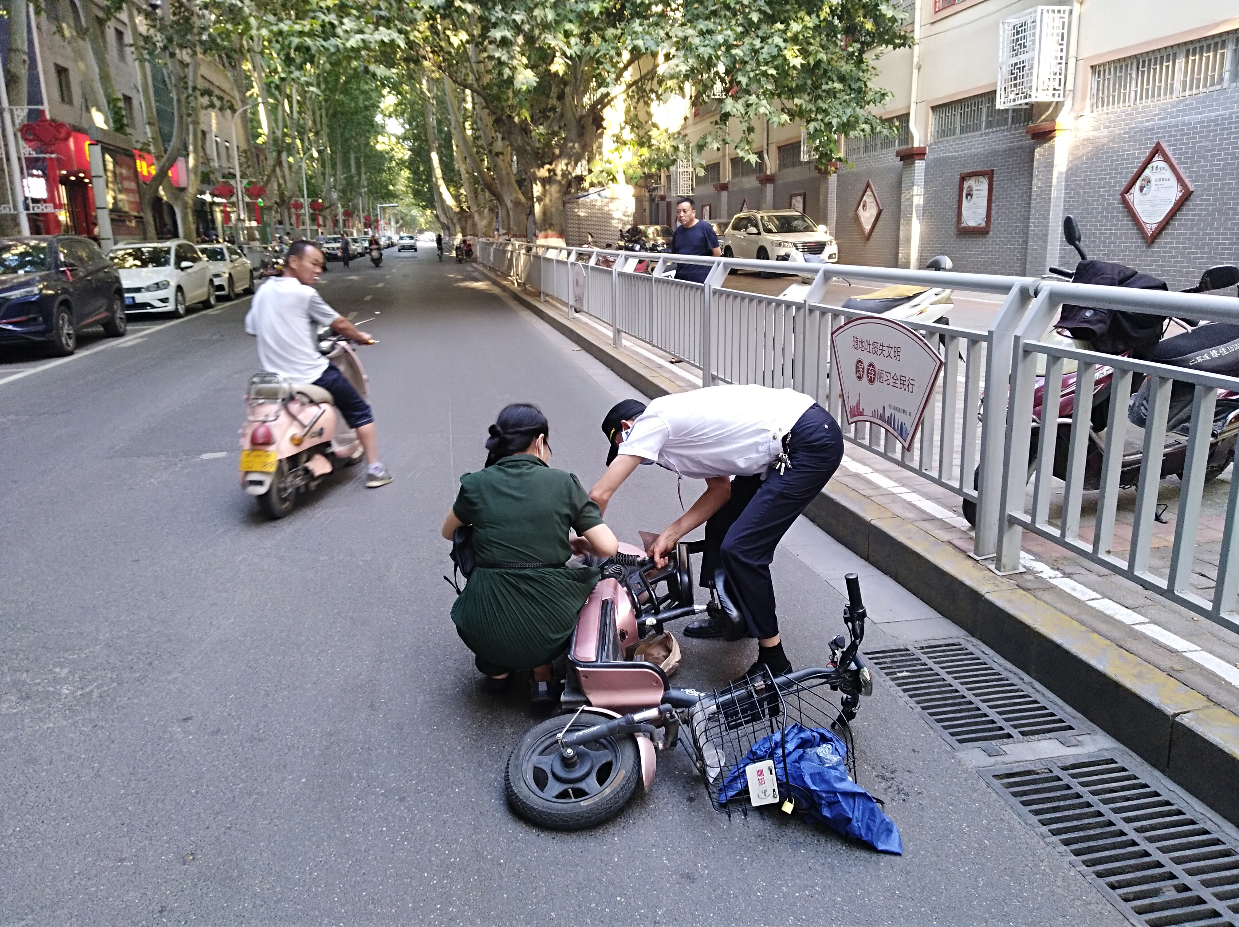 电动汽车|尴尬！女子骑电动车裙角卷入车轮，连人带车摔倒在地