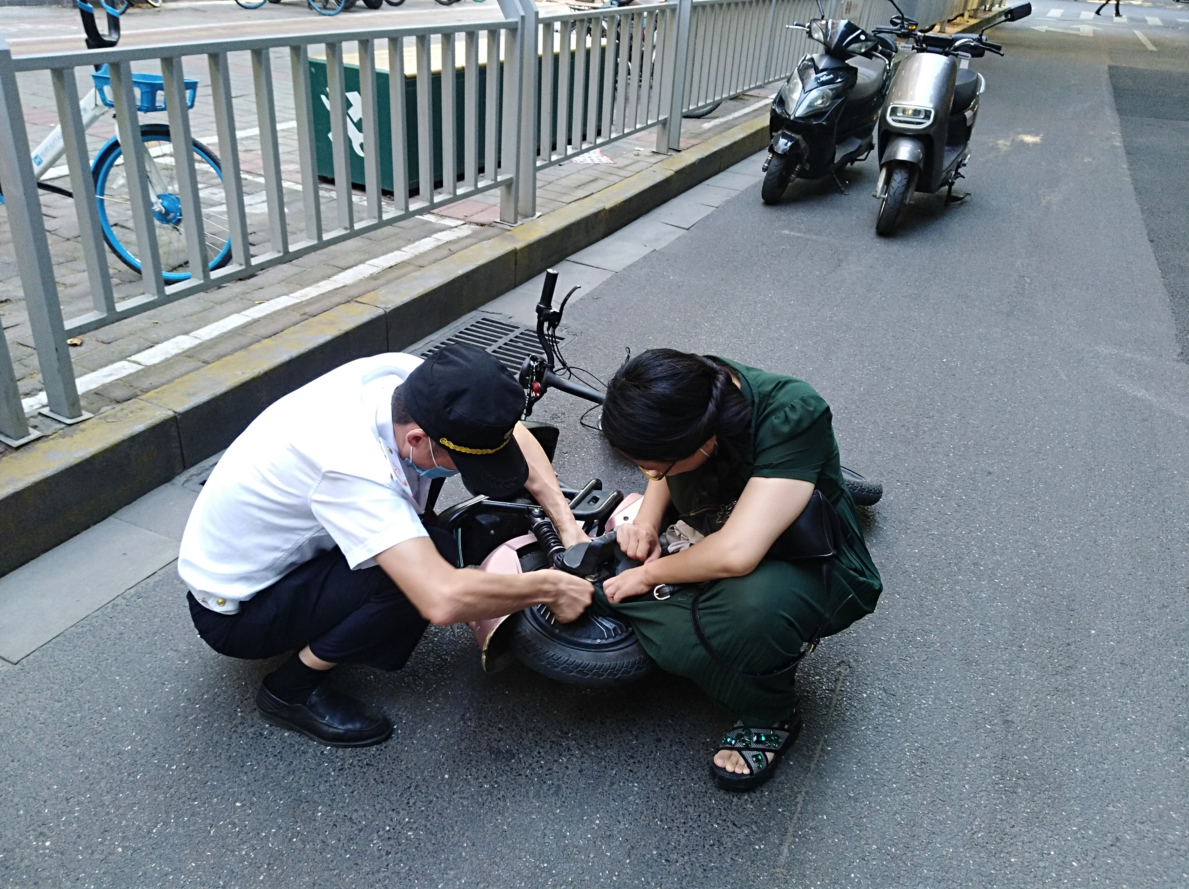 电动汽车|尴尬！女子骑电动车裙角卷入车轮，连人带车摔倒在地