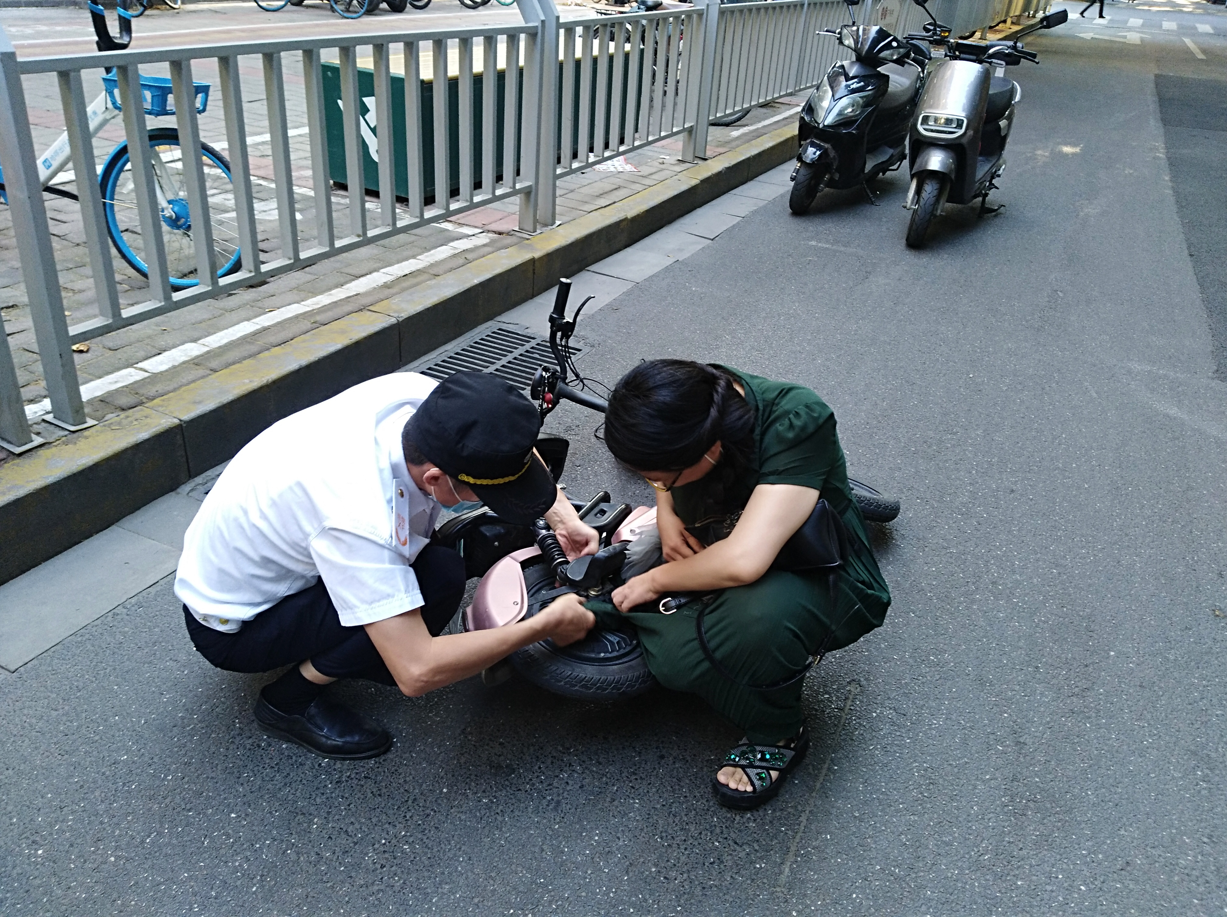 电动汽车|尴尬！女子骑电动车裙角卷入车轮，连人带车摔倒在地